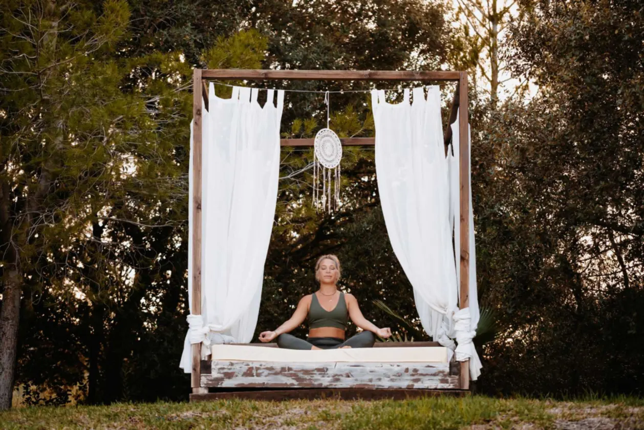 woman practicing mantra meditation on Balinese bed